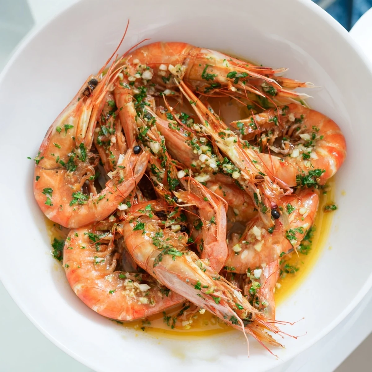 Close-up of succulent Light & Bright Lemon Herb Shrimp Scampi with vibrant herbs, swimming in a lemon-infused broth.