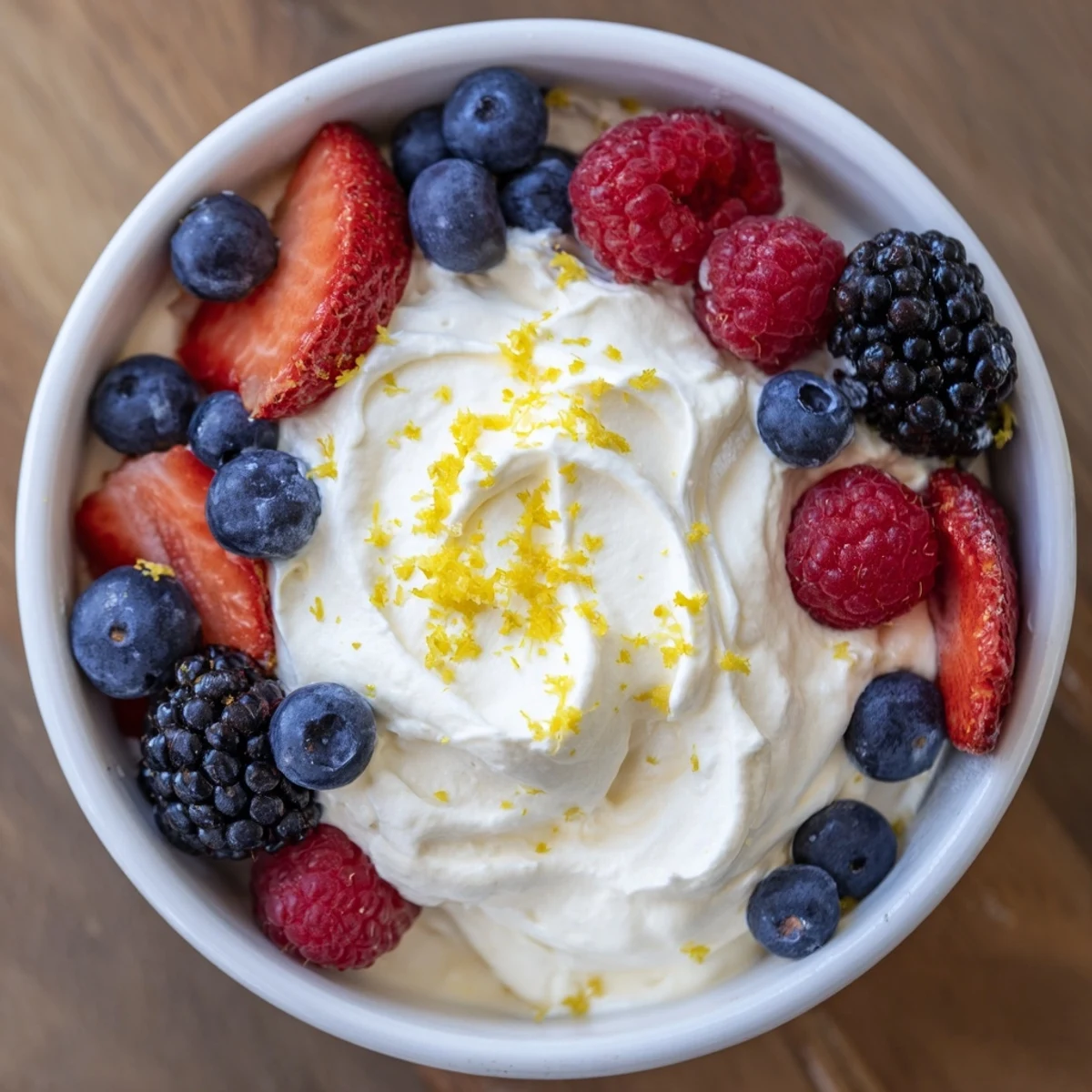 A close-up of fluffy cream cheese fruit dip with vibrant berries, a perfect easy snack.