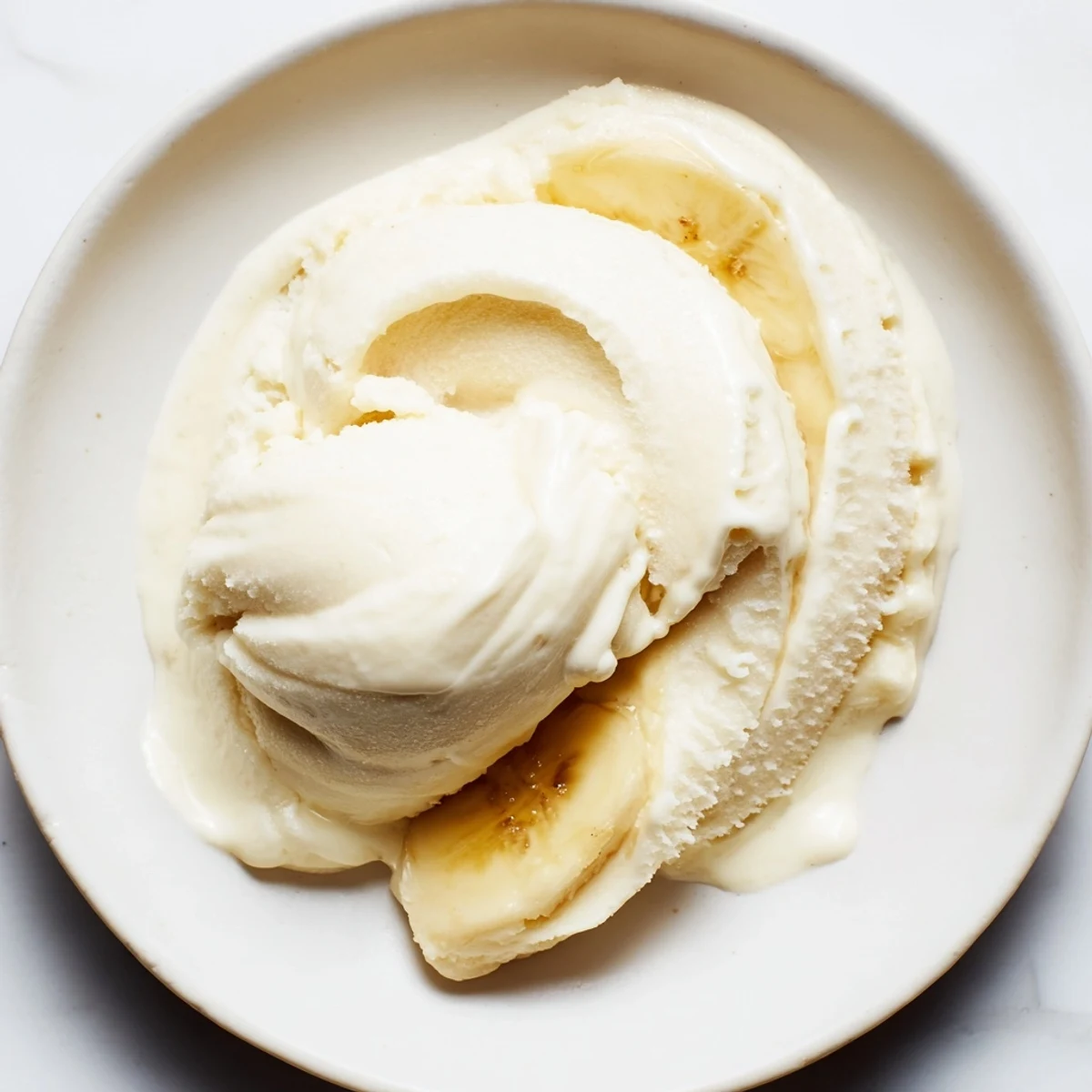 Homemade 2-Ingredient Banana Ice Cream offers a sweet, naturally frozen delight, pictured in a serving bowl.