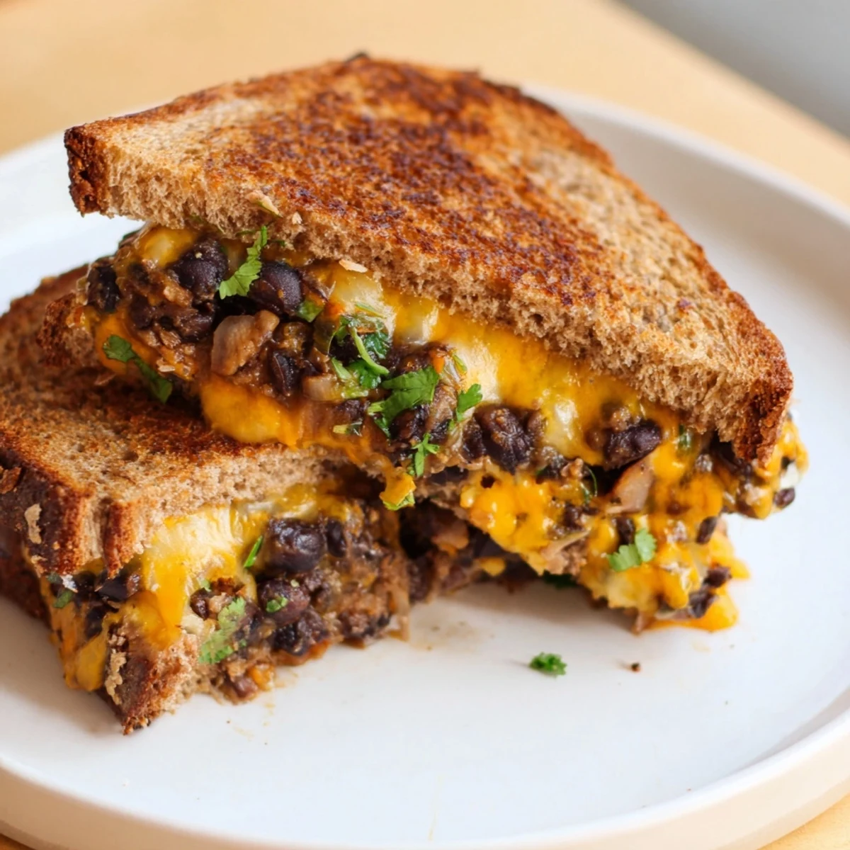 A close-up of a perfectly grilled Black Bean Grilled Cheese, oozing cheese and ready to be enjoyed.