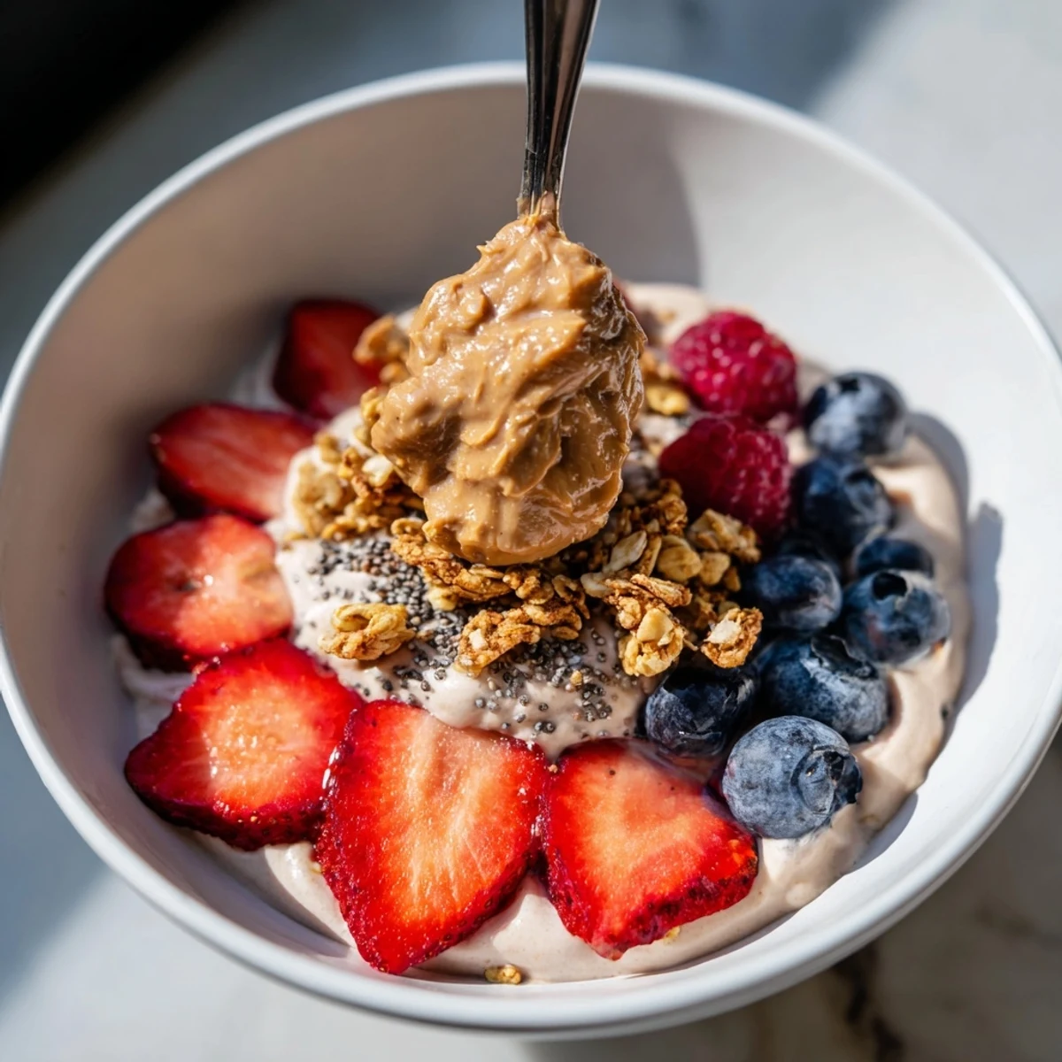 Delicious, creamy Protein Ice Cream Bowls are garnished with granola and fresh berries, a healthy dessert option.
