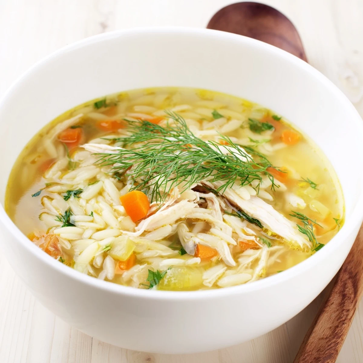 Comforting Mediterranean Chicken Lemon Orzo Soup recipe served in a rustic bowl, perfect for a cozy family dinner.