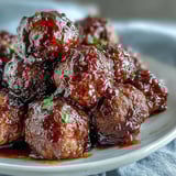 Tender Grape Jelly and Chili Sauce Meatballs in a glossy glaze, served on a platter with toothpicks for easy snacking.