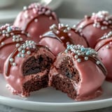 Close-up of Oreo Truffle Balls with Pink Candy Coating, revealing a rich chocolate center under a thick, crunchy shell.