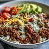 Ground beef seasoned with chili and cumin in a Low Carb Burrito Bowl, topped with juicy tomatoes, cheese, and lime.