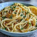 Bright and zesty lemon butter pasta dish with al dente spaghetti, melted Parmesan, and a hint of black pepper.