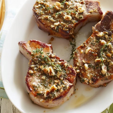 Golden-brown thyme and pecan crusted pork tenderloin, ready to slice, promising a flavorful, juicy bite.