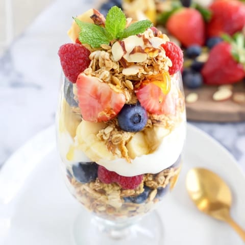 Enjoy the light, refreshing layers of this Yogurt and Granola Parfait, featuring a colorful fruit topping.
