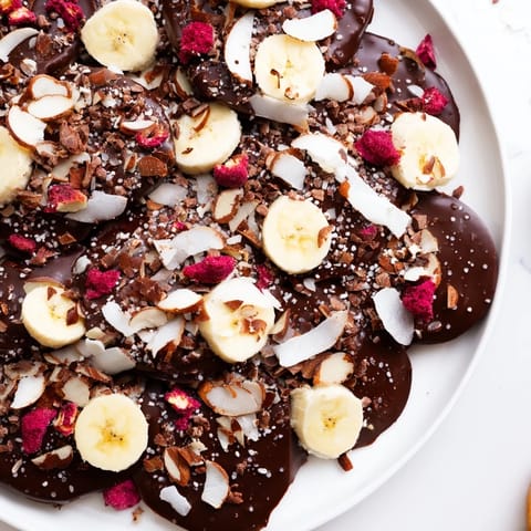 Enjoy a close-up of decadent chocolate banana bark, sprinkled with almonds and freeze-dried berries.
