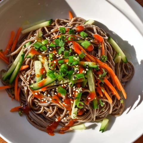A close-up view of fresh Chilled Noodle Lunch Cups, featuring a drizzle of sesame sauce and sesame seeds.