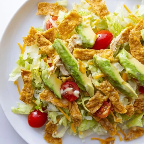 Vibrant Tex-Mex ingredients like corn, avocado, and shredded cheddar cheese are tossed with a creamy lime dressing.  