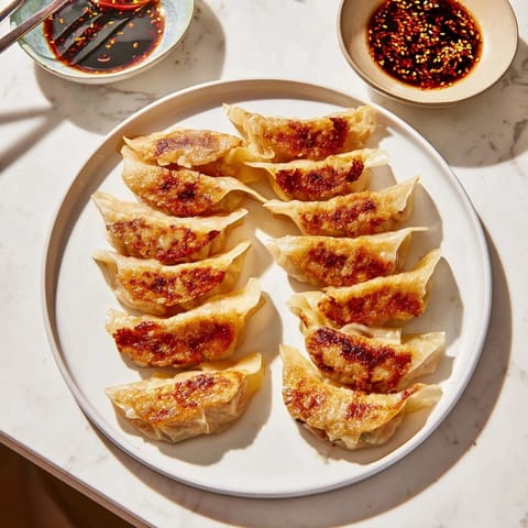 Homemade smashed gyozas on a wooden plate, crispy bottoms contrasting with tender wrappers and savory pork filling.  
