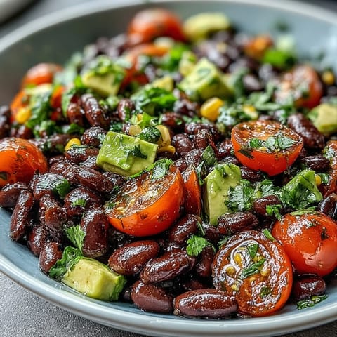 Colorful Black Bean and Veggie Bowl with corn and red onion drizzled with zesty lime dressing for a healthy lunch.