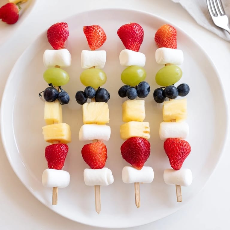 These festive Christmas Light Fruit Skewers feature bright grapes, strawberries, and pineapple, arranged like lights.