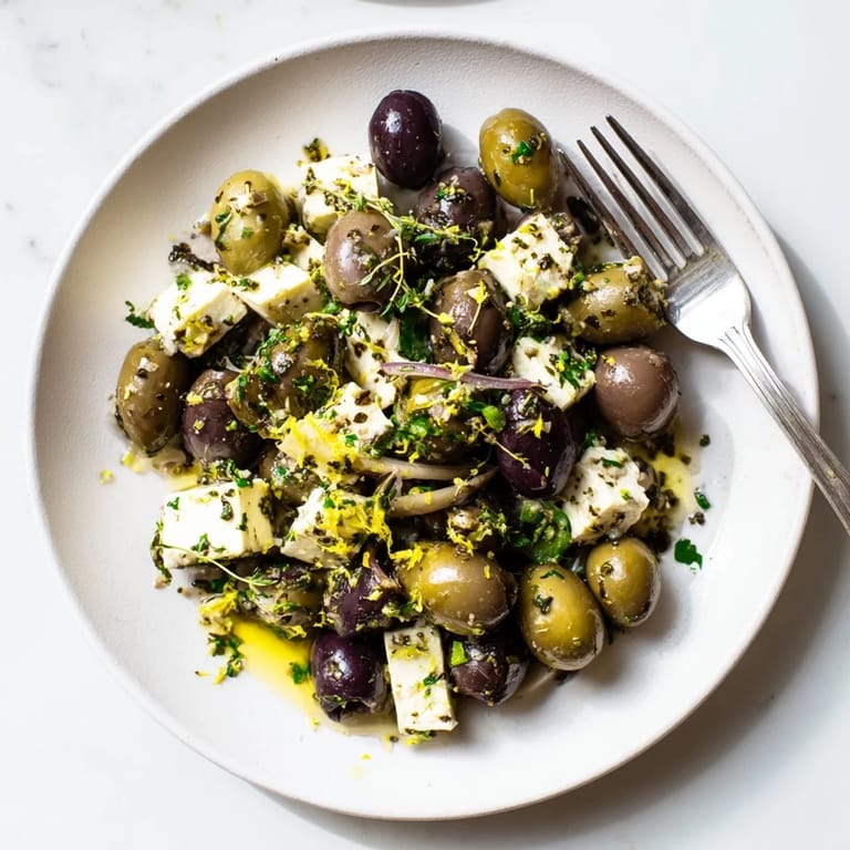 Marinated olives and creamy feta cubes in a Holiday Mix, glistening with olive oil and herbs.