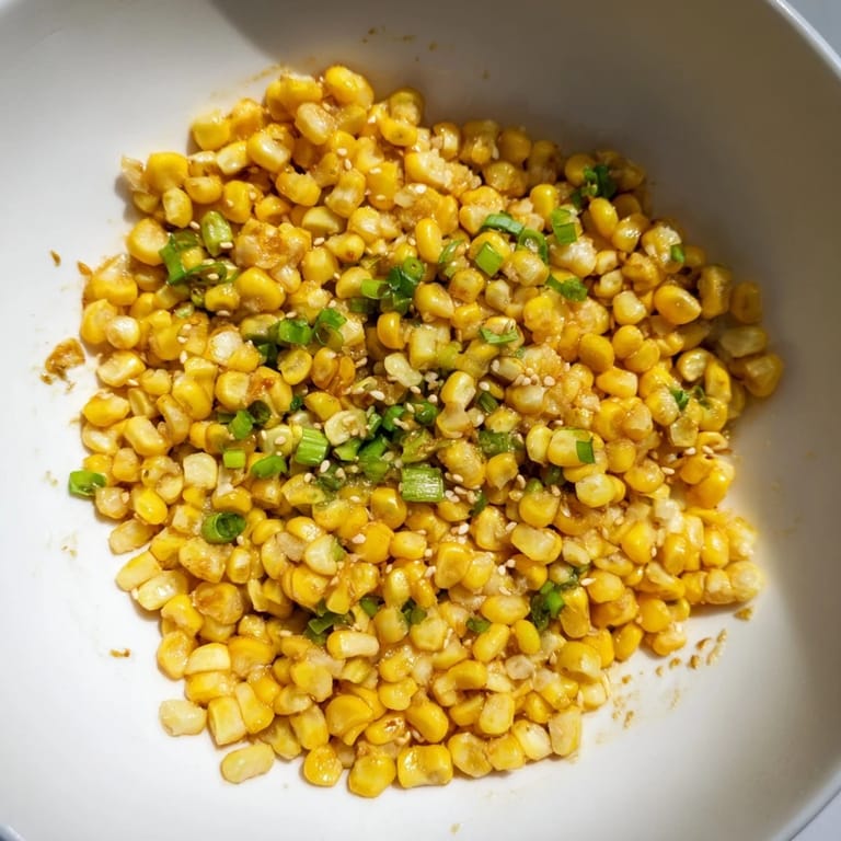 Steaming bowl of delicious Japanese Butter Corn, ready to serve with scallions, sesame seeds, and soy sauce.