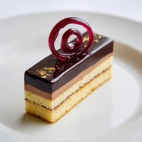 Delicious The Golden Ratio Shell, a layered dessert with raspberry jelly spiral details and shiny glaze.